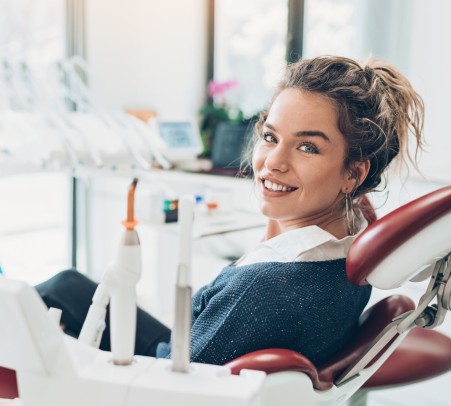 Frau lächelt in die Kamera bei einem Zahnarztbesuch