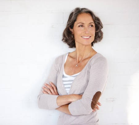 Frau lehnt zufrieden an einer Wand