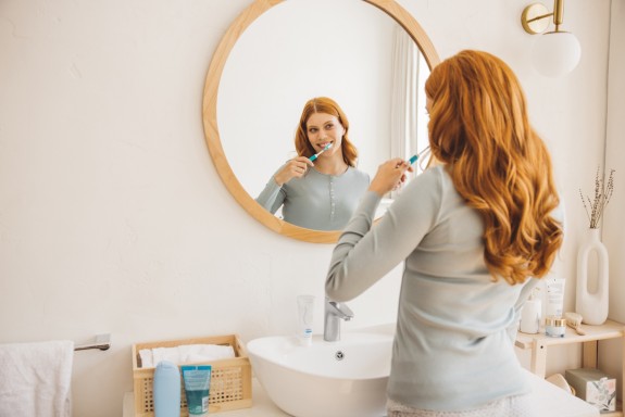 Junge Frau putzt Zähne